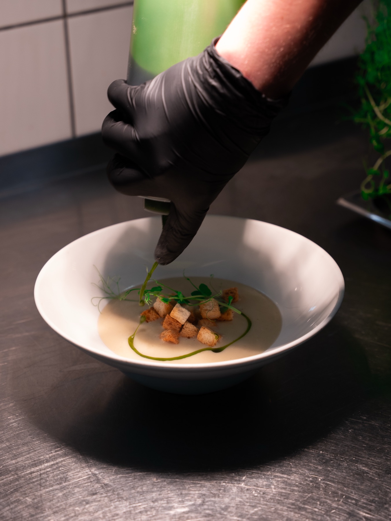 Kucharz La Margherity wykańcza danie w restauracyjnej kuchni